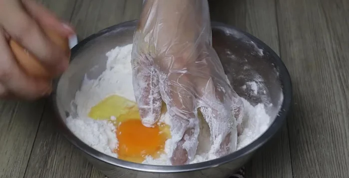 Beat the eggs and add them to the flour mixture. Knead the dough until smooth, adding water if needed.