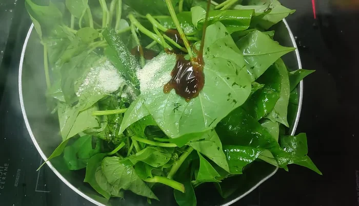 Add sweet potato leaves to the pan. Stir-fry until the vegetables are soft.