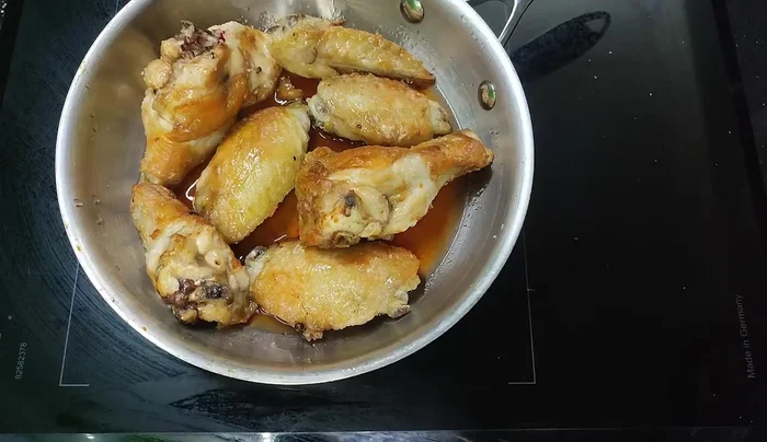 Simmer the chicken wings in the sauce until the sauce thickens. Alternatively, you can reduce the sauce separately and then add the chicken.