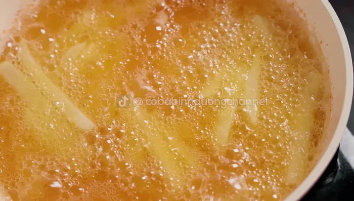 Fry the potatoes until light yellow. Remove and drain the oil.