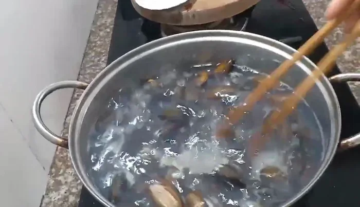 Boil the worms in a pot. Stir frequently with chopsticks to help them open their mouths completely.