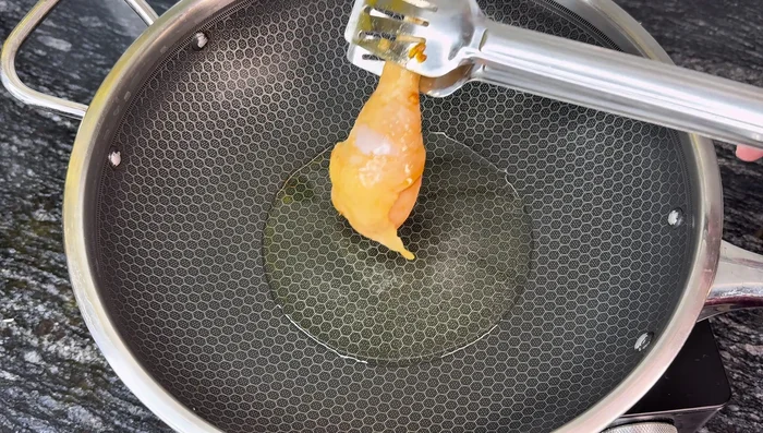 Heat cooking oil in a pan. Fry chicken thighs over medium heat until firm.