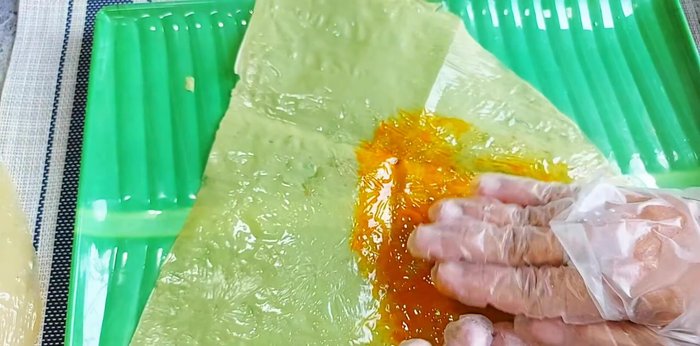 Apply annatto oil to the leaves to give them a yellow color, resembling an egg. Use two leaves for a thicker egg layer.