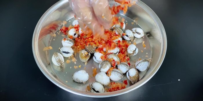 Add the prepared chili salt mixture to the cockles, ensuring they are evenly coated while still slightly wet.
