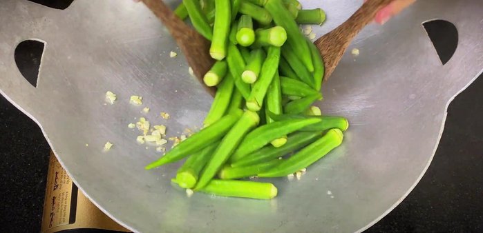 Add the okra to the pan and stir-fry over high heat until well coated with garlic. Stir constantly.