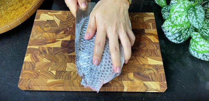 Wash the fish with salt and vinegar, then fillet it, removing the bones.