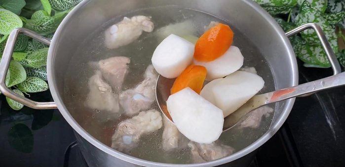 Add carrots and white radishes to the broth and simmer for 15 minutes until softened.