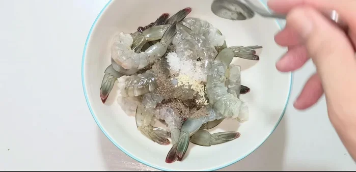 Marinate shrimp with seasoning powder, cornstarch, ground pepper, sugar, fish sauce, and minced onion and garlic for 20 minutes.