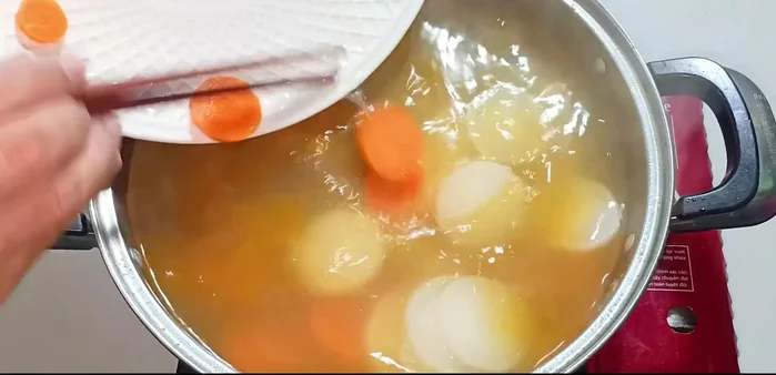 Add carrots, white radish, mushrooms, and softened rice cakes to the broth.