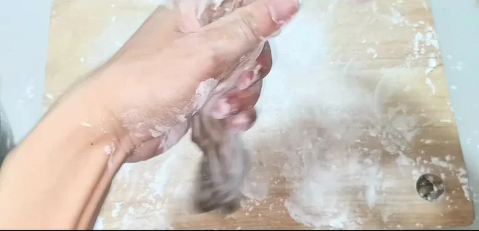 Sprinkle flour on a tray. Roll the dough into a log, then cut it into small pieces.