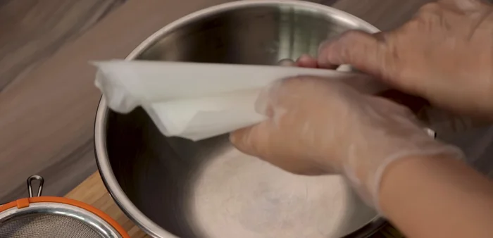 Cut parchment paper into circles or flower shapes slightly larger than your pan.