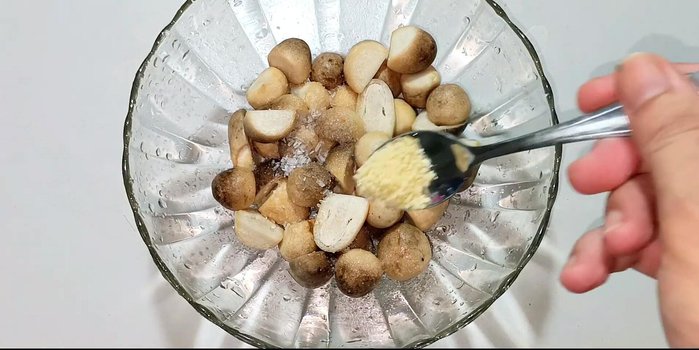Marinate the mushrooms with sugar, MSG, seasoning powder, oyster sauce, ground pepper, minced onion, and garlic for 20 minutes.
