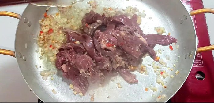 Add the marinated pig heart and stir-fry until slightly browned.