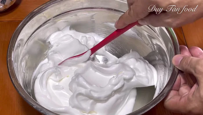Gently fold 1/3 of the beaten egg whites into the yolk mixture to lighten it. Then, fold in the remaining egg whites until just combined. Avoid overmixing.