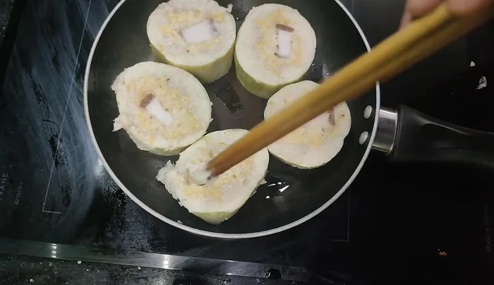 Fry the Banh Chung over medium-low heat, allowing it to heat up gradually to avoid burning.