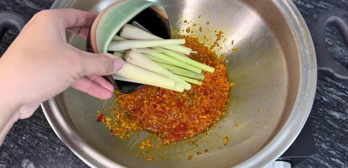 Add crushed and chopped lemongrass, stir-fry until fragrant.