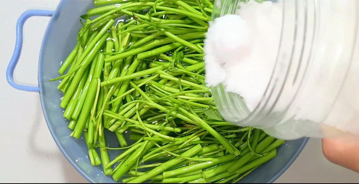 Soak water spinach in salted water for 10 minutes, then rinse and drain.