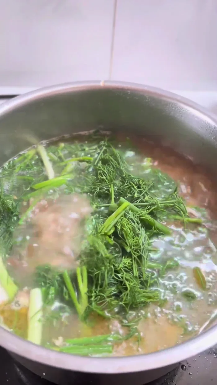 Once the fish is cooked, add dill and green onions to the soup.