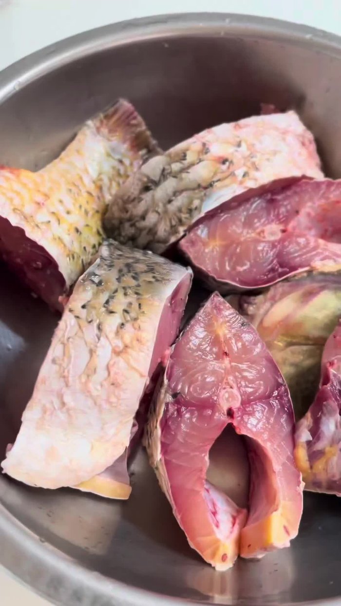 Buy carp, wash, and cut into pieces. Marinate the fish with finely chopped shallots, oil, fish sauce, MSG, seasoning powder, and sugar. Let it marinate for about 30 minutes.