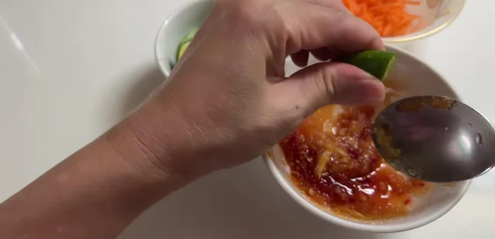 Prepare the fish sauce by mixing sugar, MSG, chili, crushed garlic, lemon juice, and fresh coconut water. Adjust the sweetness, sourness, saltiness, and spiciness to your liking.