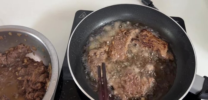 Add butter to the pan and pan-fry the beef again until cooked through. The onion marinade prevents the beef from absorbing too much oil.