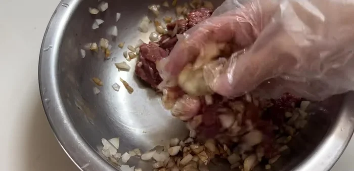 Marinate the beef with the onion mixture. Knead it evenly to allow the onion juice to penetrate the meat and make it tender.