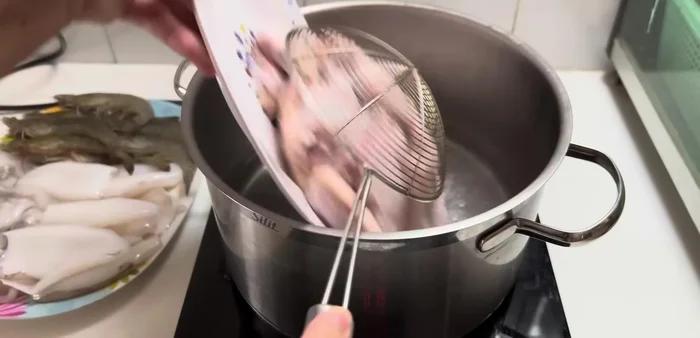 Blanch chicken wings in boiling water briefly, then immediately transfer to cold water to soak.