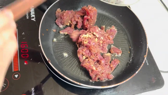 Stir-fry the marinated beef over high heat for about 3 minutes until cooked.