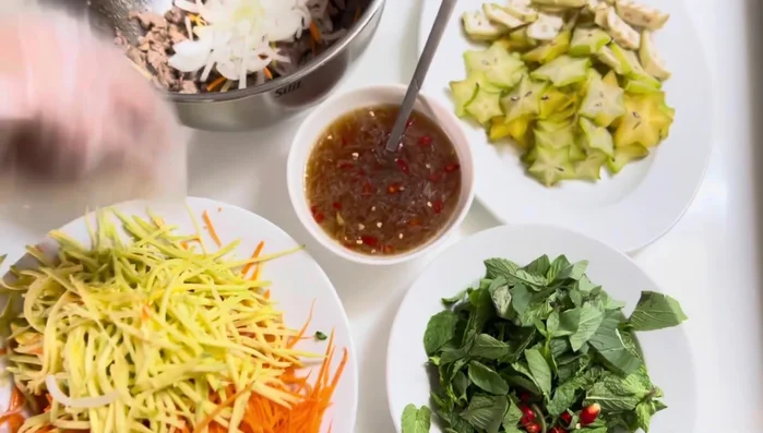 Prepare the sweet and sour fish sauce: Blend lemon, chili, garlic, sugar, and MSG with boiled water. Add fish sauce and season to taste.