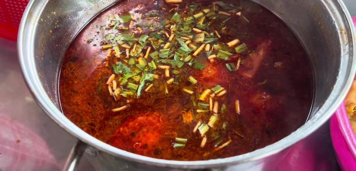 Prepare Thai hot pot broth. Include enoki mushrooms, various countryside vegetables (water lilies, water spinach mentioned), and sour and spicy ingredients.