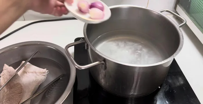Prepare a new pot of water, add shallots, seasoning, and salt. Boil the pork belly again for 15-17 minutes over medium heat, uncovered.
