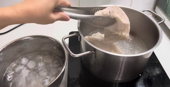 After 17 minutes, remove the pork belly and place it in ice water.