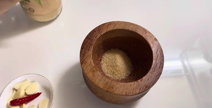 Prepare the fermented shrimp paste sauce: Crush garlic and chili. Mix with shrimp paste, sugar, fish sauce, MSG, and lemon juice.