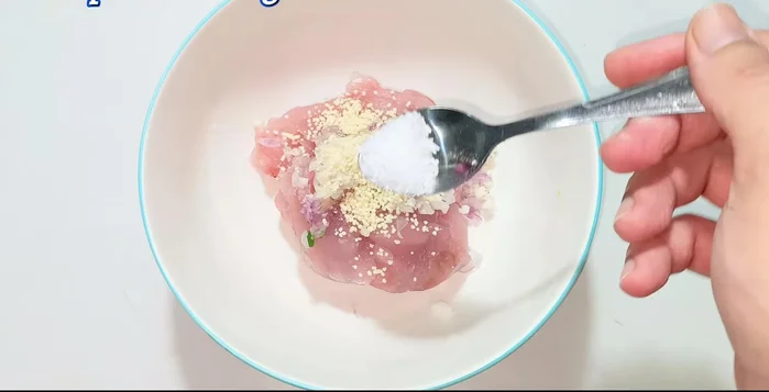 Marinate fish cakes: Mix half of the chopped garlic with seasoning powder, MSG, ground pepper. Add oil to prevent sticking. Knead and squeeze evenly to distribute seasoning.