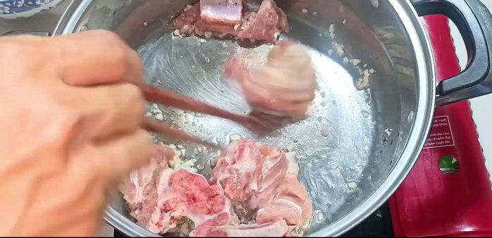 Add the marinated pork bones to the pot and stir well until lightly browned. (87.04)