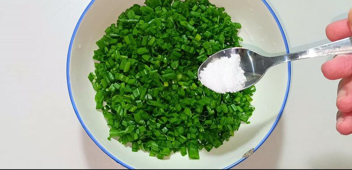 Add 1/2 teaspoon of salt and 1/2 teaspoon of sugar to the chopped green onions.