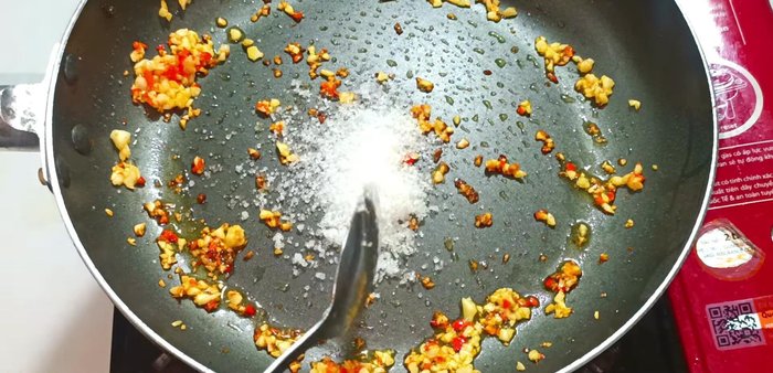 Turn off the heat and add sugar, MSG, fish sauce, water, and chili sauce to the garlic and chili mixture. Stir well.