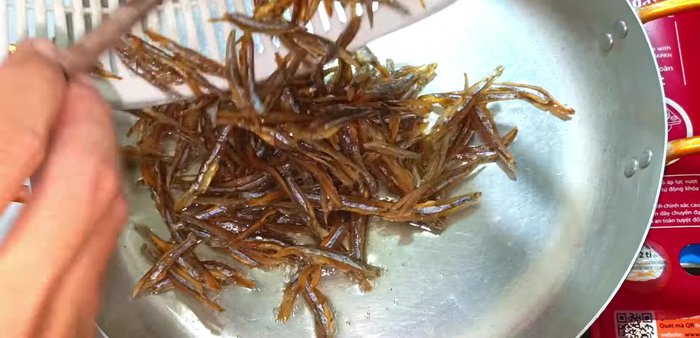 Heat cooking oil in a pan. Fry the drained anchovies until crispy, stirring frequently for even cooking.
