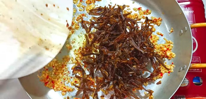 Add the fried anchovies to the pan with the garlic and chili. Mix well to coat the anchovies.