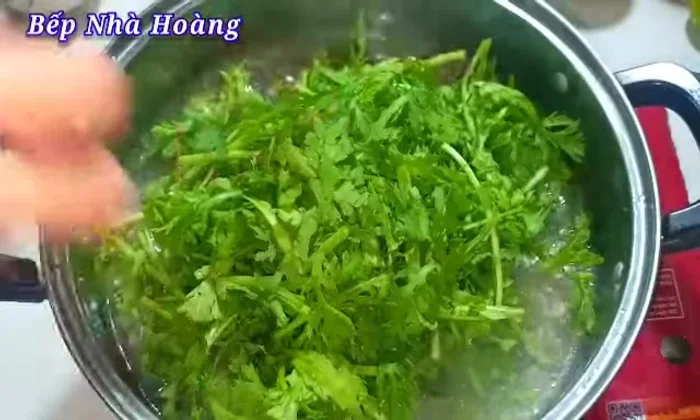 Add the washed rau tang o, stir to ensure even cooking.