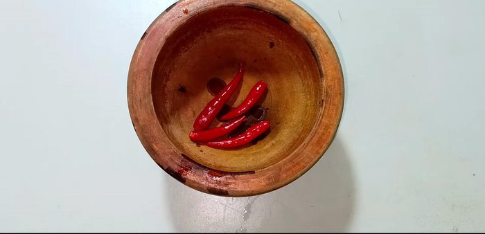 Pound the chili peppers slightly in a mortar and pestle.