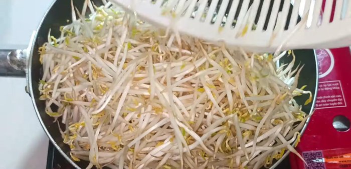 Add the bean sprouts and chives to the pan. Stir-fry until the bean sprouts are slightly softened. (103.24)