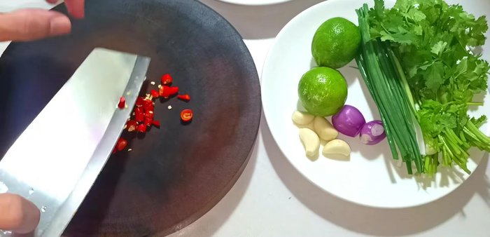 Cut chili peppers and place them in a fish sauce bowl. Cut two lemons.