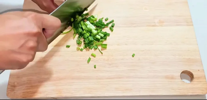 Finely chop green onions, garlic, and chili peppers.