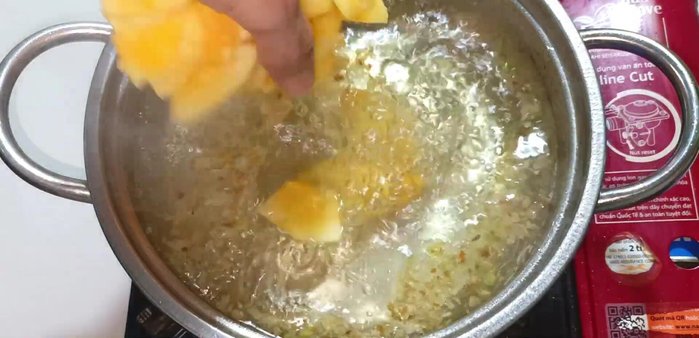 Add the sliced papaya to the boiling water, pressing it down to submerge it.