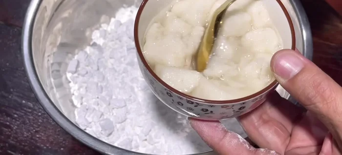 Gradually add 200g rice wine to the flour mixture, mixing until a dough forms. Do not add water at this stage.
