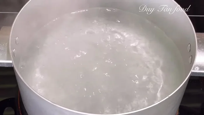 Boil the potato starch and banh ao mixture in a pot of boiling water for 6-7 minutes, stirring constantly to prevent sticking.