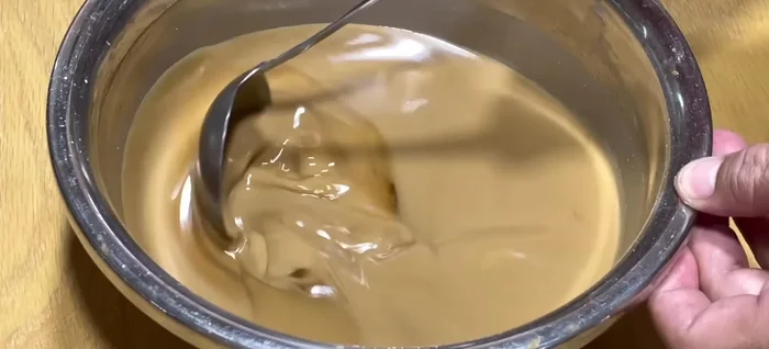 Steam the cake. Grease a 20cm round mold. Preheat for 1-2 minutes. Pour in the coffee batter (about 100ml per layer), steam over low heat for 4 minutes. Add the mung bean layer (about 100ml per layer), steam over medium heat for 5 minutes. Continue alternating layers, increasing steaming time by 1 minute for each subsequent layer (up to 8 minutes). For the last layer, steam for 15 minutes.