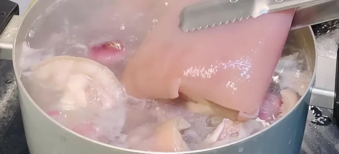 Remove pig skin after 15 minutes; boil pig hands for an additional 5 minutes. Immediately transfer to an ice bath to firm the skin.