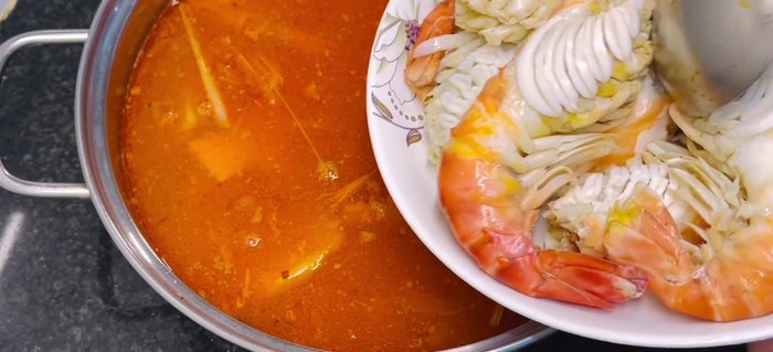 Add the steamed crayfish to the boiling hot pot. Cook briefly until heated through. Add vegetables and garnish with the reserved whole crayfish.